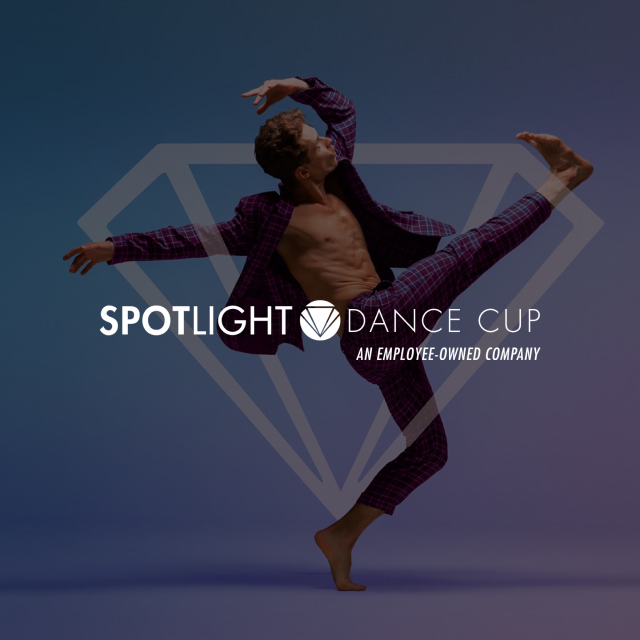 A male dancers behind a Spotlight Dance Cup logo